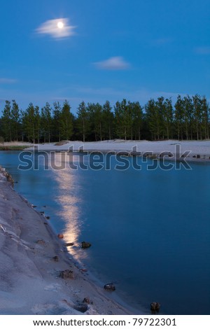 moon shining over river at blue hour