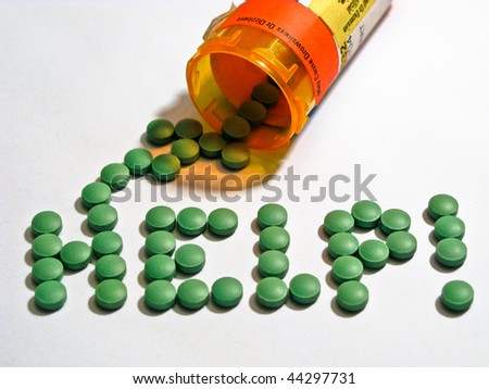 help spelled out in green medicine pills spilled from a medicine bottle