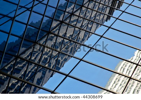old office building reflection in a modern glass office building