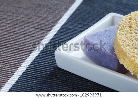 Soap bar with natural ingredients and sponge in dish
