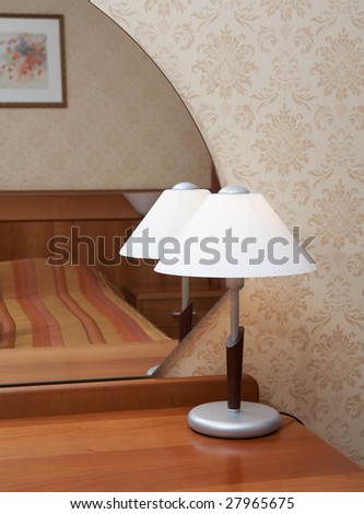 Lamp in front of mirror in a modern bedroom