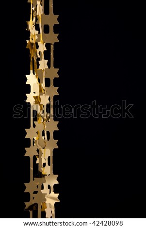Christmas decoration gold stars garlands on black background with empty place for your text
