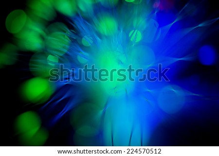 Sparkling unusual background with patches of light and fibers of green and blue light.