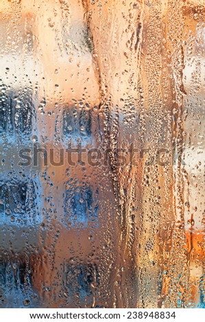 Frozen drops of rain on windowpane at sunset. Bright multi-colored abstract background.