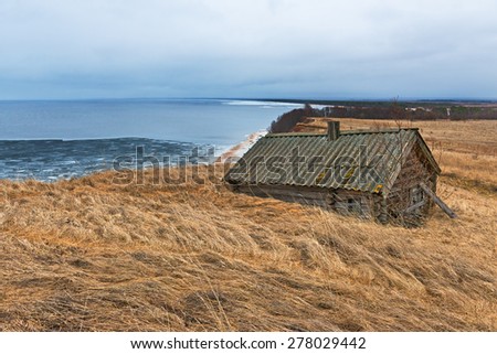 Windy April day on the Onega lake and  lonely old house in foreground.