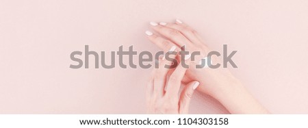 Long wide banner of woman moisturizing her hand with cosmetic cream lotion with copy space on millennial pink background minimalism style. Concept template feminine blog, social media, beauty concept