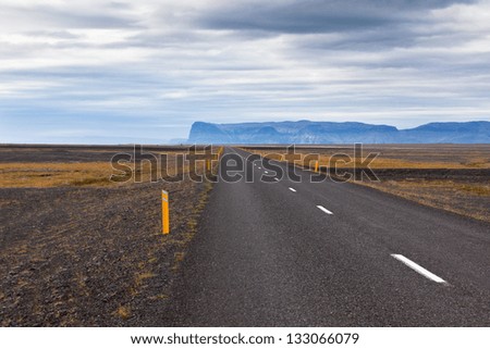 Highway through Iceland landscape at overcast day. Horizontal shot