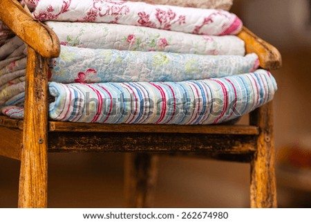 Handmade blankets pile. Vertical outdoor shot with selective focus. Natural light