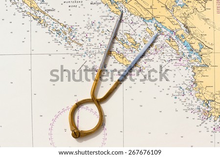 Pair of compasses for navigation on a sea map. Horizontal shot