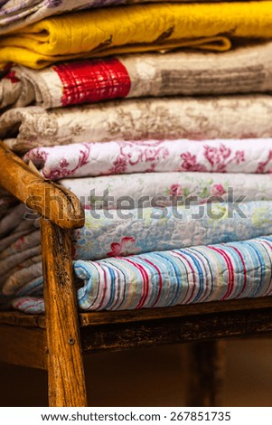 Handmade blankets pile. Vertical outdoor shot with selective focus. Natural light