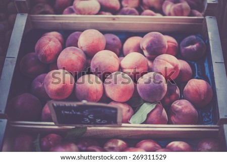 Ripe fresh peaches in a french farmers market. Horizontal filtered shot with a selective focus