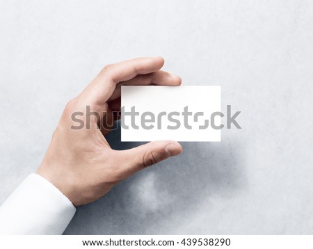 Hand hold blank plain white business card design mockup. Clear calling card mock up template holding arm. Visit pasteboard paper surface display front. Check small offset card print. Business branding