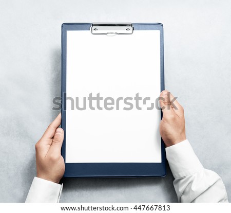 Hand holding blank clipboard with white a4 paper design mockup. Clear document holder mock up template hold arm. Clip board notepad surface display front. Checklist tablet plan file presentation.
