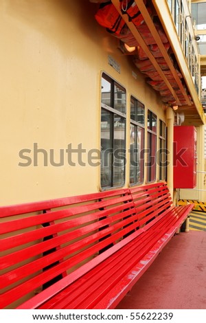 Empty red bench seat on ferry boat