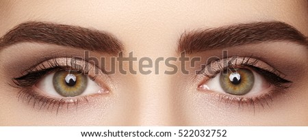 Close-up macro of beautiful female eye with perfect shape eyebrows. Clean skin, fashion naturel make-up. Good vision