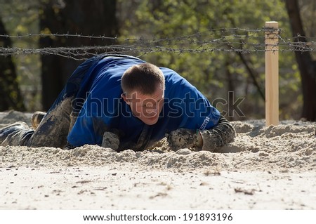 RUSSIA, DMITROV REGION, SHUKOLOVO VILLAGE - APRIL 26: Unidentified man crawling on sand on survival festival game NaPredele (On the edge) on April 26, 2014, in Dmitrov region, Shukolovo, Russia