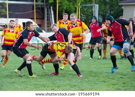 MOSCOW, RUSSIA - MAY 13: Ivan Karasev (12) fall down on Russian Rugby Championship 2014 game Slava CSP (yellow) vs Metallurg (black),  on May 13, 2014, on Slava stadium, in Moscow, Russia