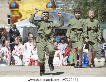 ELECTROUGLI, RUSSIA - MAY 9: Teen artists in military uniform dance with a sword on a concert dedicated The Victory day in World War II on May 9, 2014, in Electrougli city, Ivanovskoe village, Russia