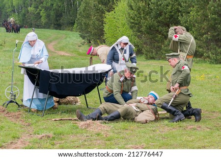 RUSSIA, CHERNOGOLOVKA - MAY 17: Unidentified men of medical squad helps wounded soldier on History reenactment of battle of Civil War in 1914-1919 on May 17, 2014, Russia