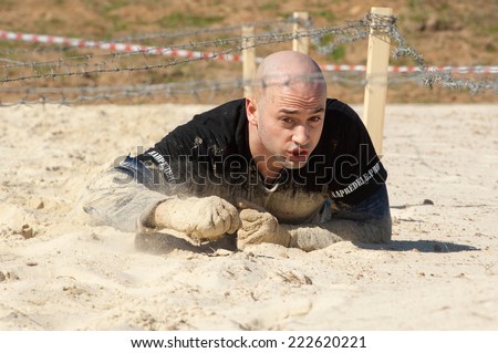 RUSSIA, DMITROV REGION, SHUKOLOVO VILLAGE - APRIL 26: Unidentified man crawling on sandy place on survival festival game NaPredele (On the edge) on April 26, 2014, Shukolovo village, Russia