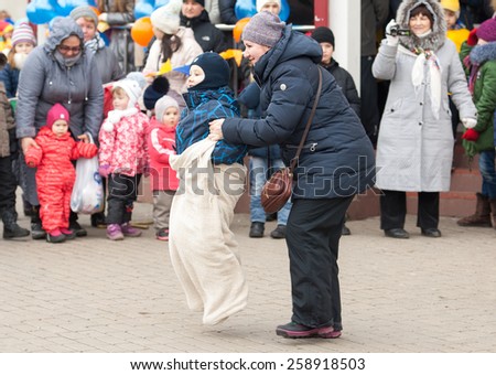 MOSCOW, RUSSIA - FEBRUARY 22: Unidentified woman with boy running on Russian religious and folk holiday Maslenitsa near Culture center Peresvet on February 22, 2015, Russia