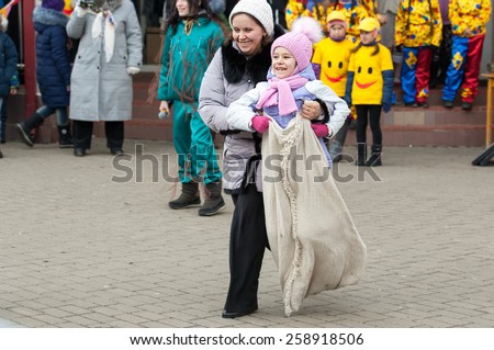MOSCOW, RUSSIA - FEBRUARY 22: Unidentified woman and girl on running sack competition on Russian religious and folk holiday Maslenitsa near Culture center Peresvet on February 22, 2015, Russia
