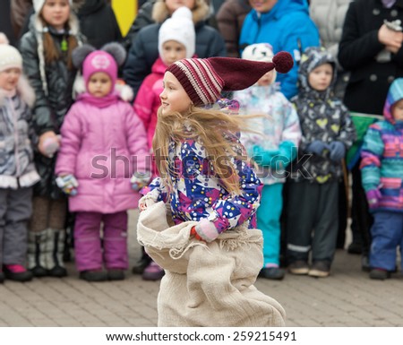 MOSCOW, RUSSIA - FEBRUARY 22: Unidentified girl running on Russian religious and folk holiday Maslenitsa near Culture center Peresvet on February 22, 2015, Russia