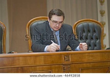 The Man is correcting something by pen on document.