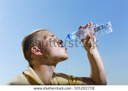 The young man pours water from a bottle