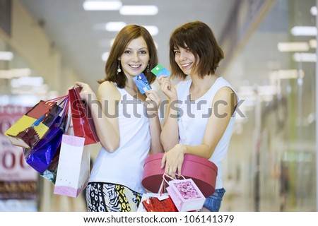Two girls with packages show credit cards
