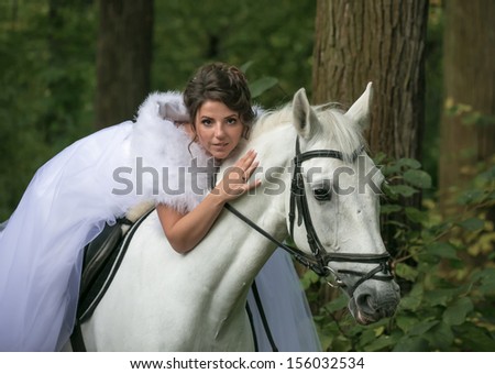 The young beautiful woman on a white horse