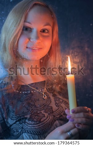 Portrait of the young woman with a candle