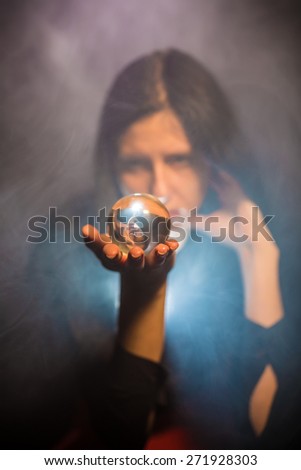 The woman holds a magic sphere