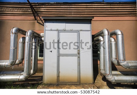Wall with a door in which pipes enter