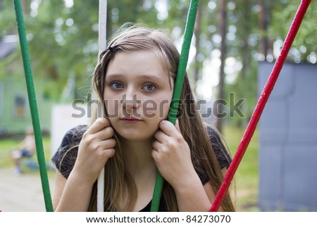 Little girl put her head among coloured horizontal bars