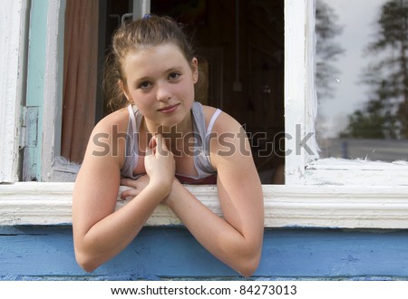 Young pretty girl leans out of the window
