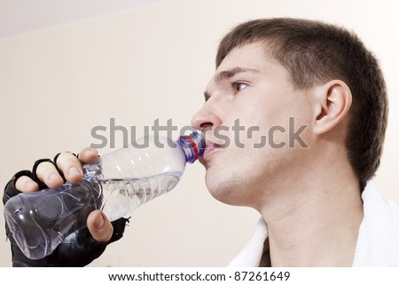Sportsman drinks water from a plastic bottle