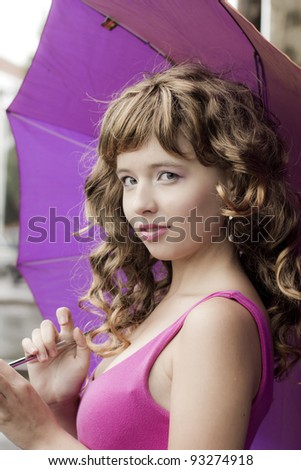 The beautiful girl under a lilac umbrella