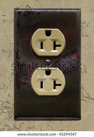 Aged, damaged, electrical outlet on worn plaster wall