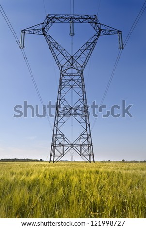 Infinite row of some high voltage metal pillars on the wheat field
