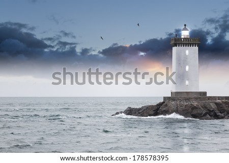 Old famous lighthouse in front of the straight horizon. The fog disappeared in no time