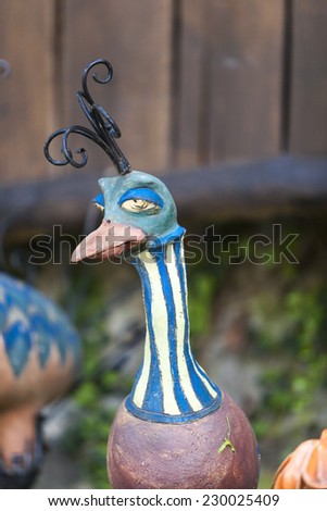 Funny ceramic decoration in the garden with a bird figure