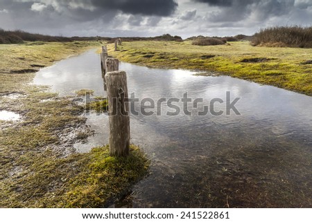 Small water covered pathway coastline in France at the end of a stormy day.