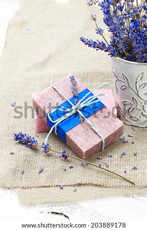 Bunch of lavender flowers,soap  on old wooden background.Spa treatment.