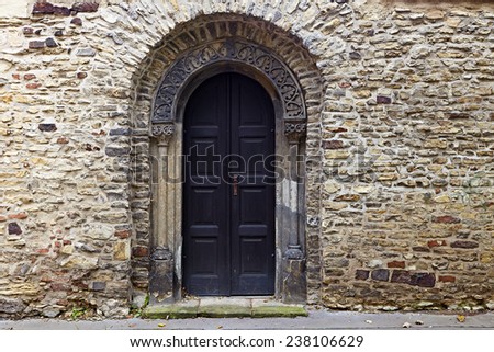 Old black door against an old stone wall