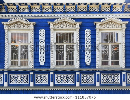 wall of wooden traditional russian house with windows and carved frames and pattern