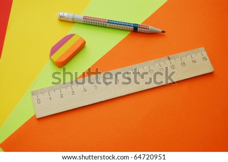 close up of four colourful papers, pencil, ruler and eraser