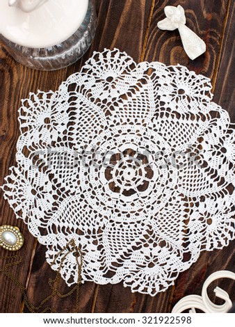 White openwork knitted cloth on a wooden table, top view