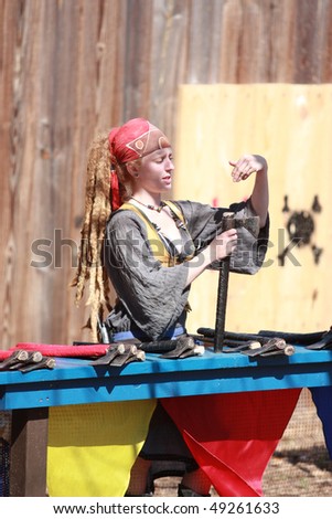 TAMPA FLORIDA- MARCH 13: A woman in costume tends the ax throwing game at the Renaissance Festival on March 13, 2010 in Tampa, Florida