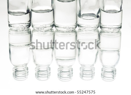 Laboratory glass vials with liqueur inside, without top, with reflection